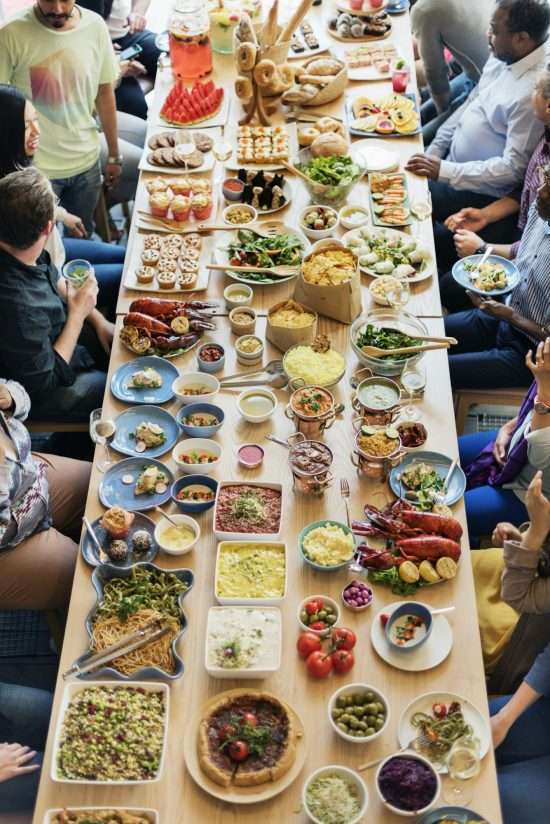 Firmenevent mit vielen Personen mit viel Essen an einer großen Tafel